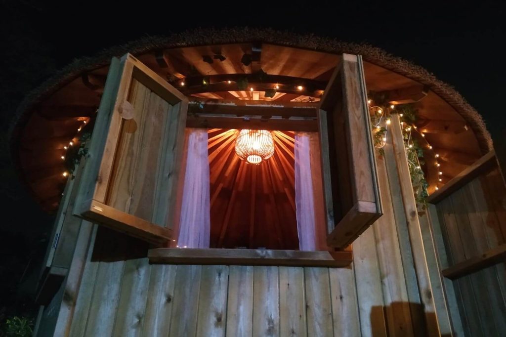 Treehouse at night time with light coming from inside through windows