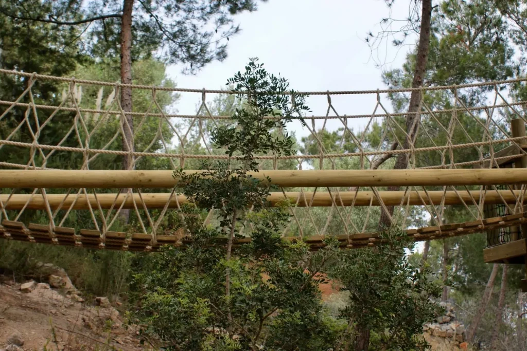 Fixed-Beam Rope Bridge set amongst trees in Ibiza landscape.