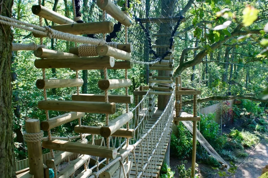 Family garden with a suspended Rope Bridge between two trees with a 4-sided Rope Ladder at each end