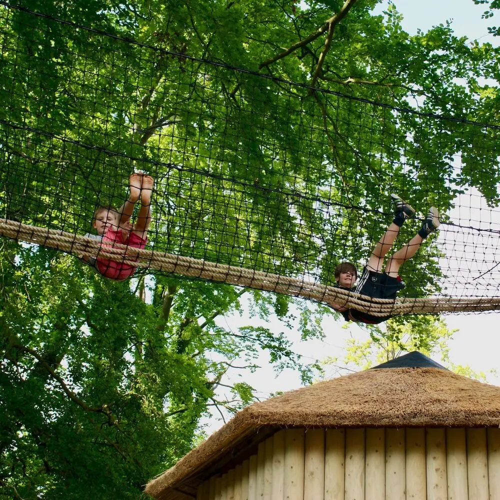 treehouse+boy+treetop+walkway+adventure Boy sitting in a Treetop Walkway near a Treehouse